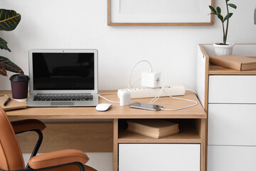 Workplace with gadgets and charger in office