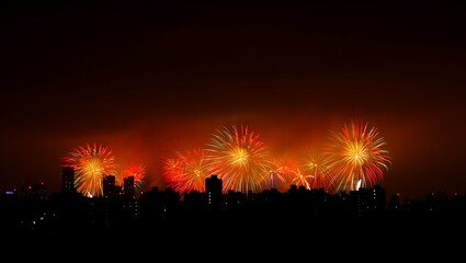 Spectacular night sky illuminated by a vibrant display of colorful fireworks exploding over a silhouetted crowd watching the celebration