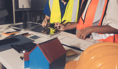 Closeup of team of industrial engineers meeting analyze machinery blueprints consult project on table in manufacturing factory. Working in manufacturing plant or production plant.
