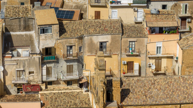 Aerial close-up of houses, buildings, and apartments in the historic center of Agrigento, Sicily, Italy. Traditional southern Italian homes.