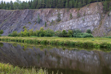 A rocky hillside with a river running through it