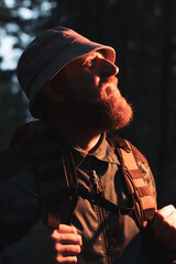 A man with a beard and a hat is looking at the camera