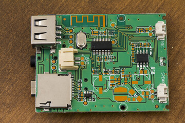 Oblique close-up of a green Bluetooth MP3 decoder board showing USB-A host port, micro-SD/TF card slot, 3.5 mm audio jack, USB-C power, JST battery/speaker headers and PCB Bluetooth antenna, isolated 
