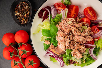 Tuna salad canned fish, tomato, green leaf salad vegetable dish tasty snack fresh gourmet food background on the table rustic top view copy space keto and paleo diet vegetarian food pescetarian diet