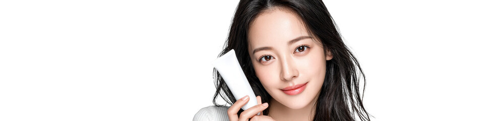 Young attractive individual smiling while holding a smartphone in a bright studio setting during the day