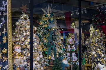 luxury christmas tree window display with white and gold decorations at a retail store for holiday shopping, visual merchandising, and concept of seasonal retail