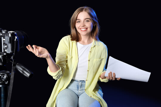 Young actress recording her audition on black background