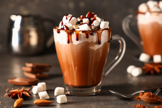 Glass cup of hot cocoa drink with whipped cream, marshmallows and liquid chocolate on dark background - Powered by Adobe