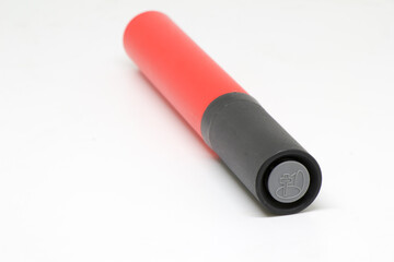 Angled close-up of a red-and-black handheld ball pump, isolated on white