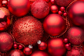 Close up of pile red Christmas balls, various size, shades and textures. Christmas Holiday...