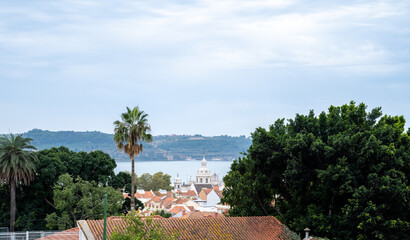Scenic view of Lisbon rooftops and Tagus river under cloudy skies