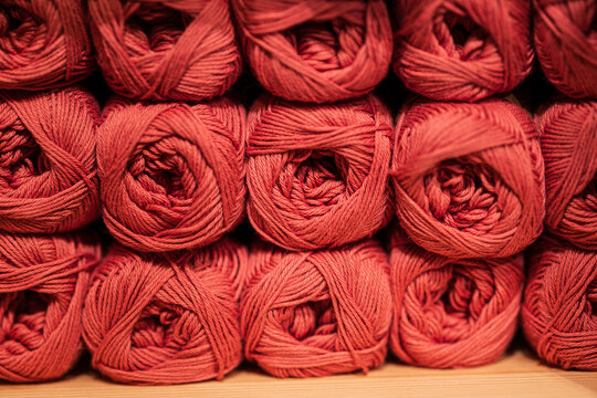 Neatly stacked red yarn skeins in store display.