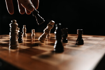 Close view of a black piece striking the white king, capturing a dramatic finishing move and the concept of victory over an opponent.
