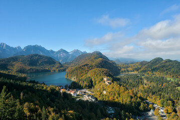 Panoramic view of the Alpsee lake, Hohenschwangau Castle area, and the rugged Bavarian Alps.