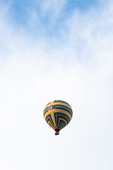 Colorful hot air balloon floating across blue sky