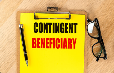 Words contingent beneficiary written on yellow clipboard with pen and eyeglasses on wooden table