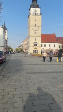 Vertical video with a sliding upward camera movement showcasing the historic City Tower in Trnava's main square and its clock and observation deck