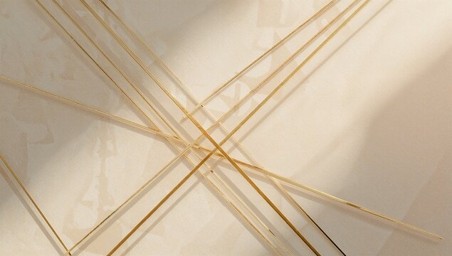 A close up of golden geometric lines intersecting on a light surface creating abstract patterns