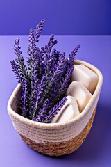 Lavender soap. Beauty and health. Lavender flowers are beautifully arranged alongside white soap bars in woven basket, creating serene and calming aesthetic against vibrant purple background