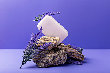 Lavender soap. Beauty and health. White soap bar elegantly positioned on rough rocks, surrounded by fresh lavender sprigs, creating serene and calming atmosphere with vibrant purple backdrop