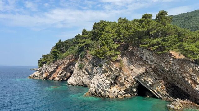 The Adriatic Sea with clear, turquoise waters washes the rocky coastline. 