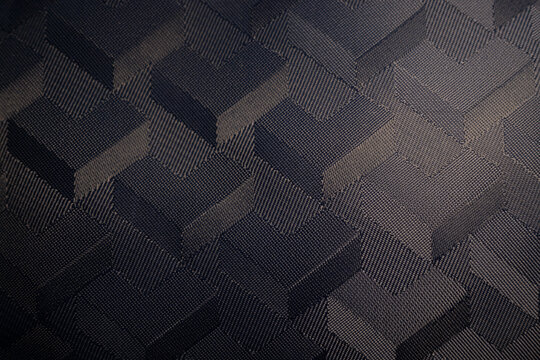 Macro of a dark woven textile with a 3D geometric cube pattern. A modern, abstract background with a sophisticated, high-tech feel and an optical illusion effect. - Powered by Adobe