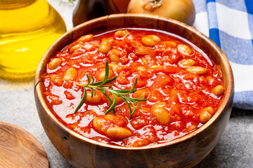Baked bean dish in wooden bowl on vintage background.
