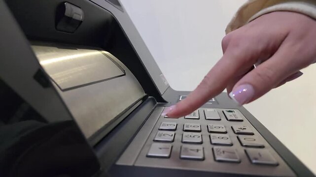Woman entering PIN code on ATM keypad during banking transaction. Close-up of finger pressing numeric buttons on automated teller machine, concept of financial security, banking access and digital pay