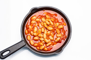 Baked bean dish in cast iron pan on white background. 