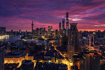 Fototapeta premium Shanghai Skyline at Sunset with Oriental Pearl Tower and Illuminated Skyscrapers