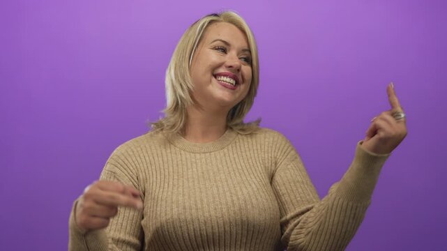 Young blonde woman wearing tan sweater shows middle finger while smirking at camera and raising eyebrow in studio; defiance.
