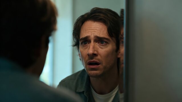 Man Looking at Reflection with Concerned Expression