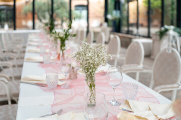 Elegant Wedding Reception Table Setting with Delicate White Flowers and Soft Pink Runner Ready for Guests Celebration Event