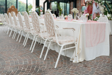 Elegant long dining table set for a special occasion with ornate chairs and soft pink table runner creating a festive atmosphere ready for guests
