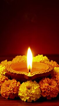 A lit diya surrounded by marigold flowers creating a warm and spiritual atmosphere indoors