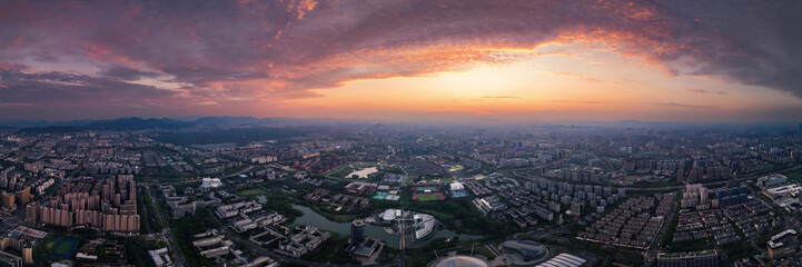 Dramatic Sunset Over Hangzhou Cityscape with Orange Clouds and Mountains