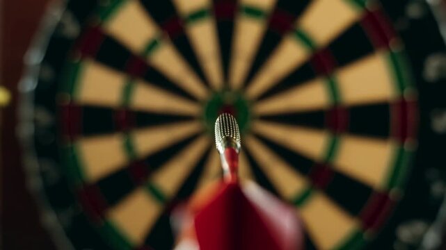 Immersive point of view shot of a red dart flying through the air and hitting the bullseye in the center of a dartboard, representing the concept of precision, success, and achieving goals