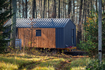 The modular house is transported through a forested area.