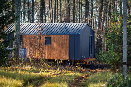 The modular house is transported through a forested area.