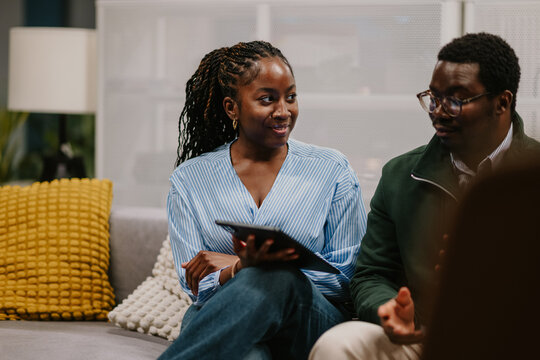 Colleagues collaborating on business meeting with tablet