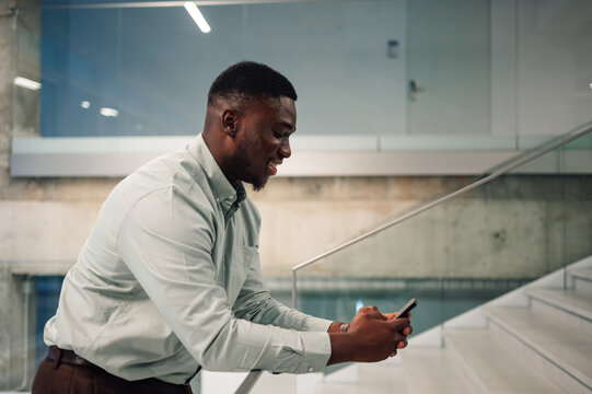 African american man using mobile phone on staircase