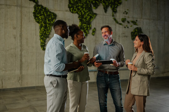 Diverse business people networking during coffee break in modern office - Powered by Adobe