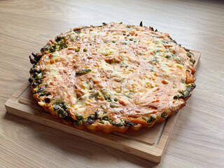 Homemade vegetable pie with cheese crust baked in round tin. Comfort food, rustic simplicity, and homemade cooking aesthetics reflecting everyday nourishment and warmth.