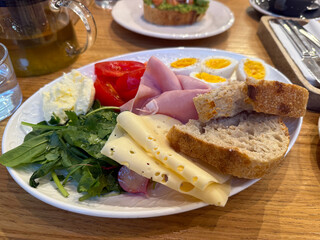 Healthy breakfast with eggs, bread, ham, cheese and vegetables. Balanced morning nutrition, fresh ingredients and homemade food inspiration.
