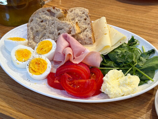 Healthy breakfast with eggs, bread, ham, cheese and vegetables. Balanced morning nutrition, fresh ingredients and homemade food inspiration.