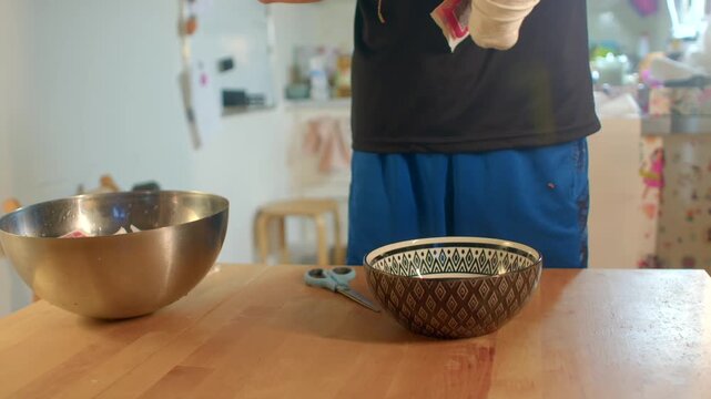bandaged hands preparing bowl and ingredients on counter, injured cook carefully unwraps gauze and pours seasoning into
