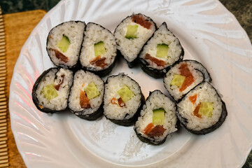 Eight Hand-Rolled Sushi Rolls Served On Wooden Surface