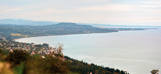 A breathtaking aerial view of a coastline bathed in pre-sunset light, where the golden hour transforms the landscape into a masterpiece of warm tones.