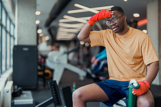 Fit African American Man Resting After Intense Workout Session In Modern Gym Environment