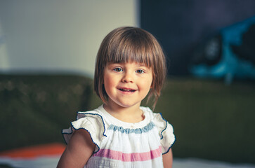 A close-up portrait of a cute little three-year-old girl